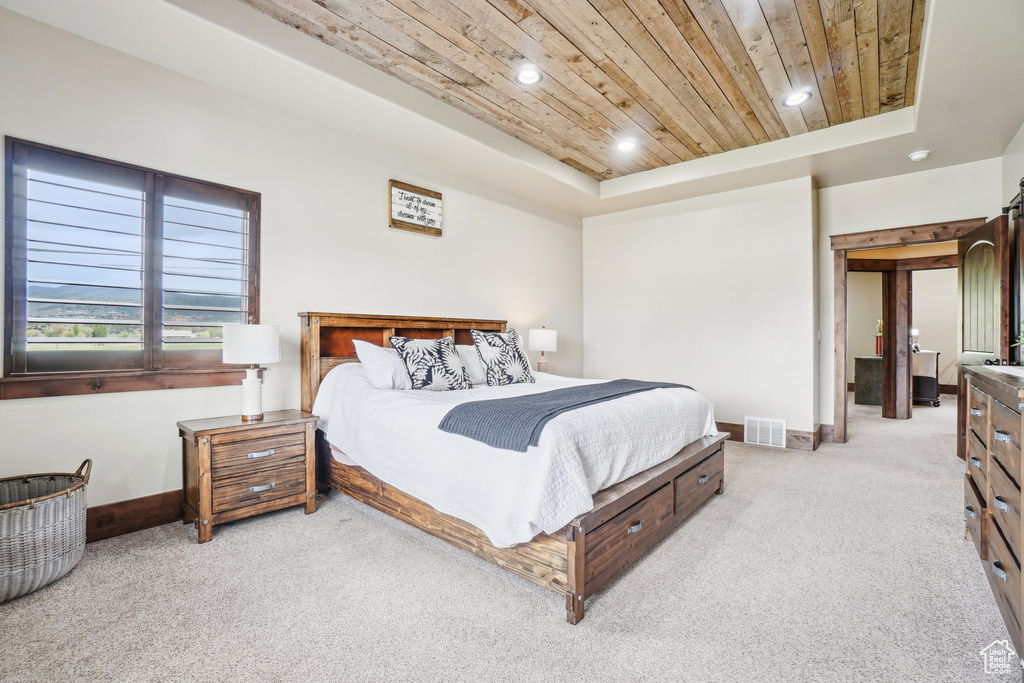 Bedroom featuring wooden ceiling, light carpet, baseboards, a raised ceiling, and recessed lighting