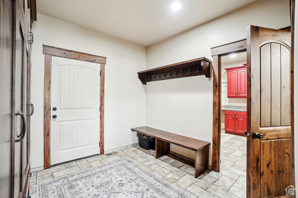 Mudroom with light stone finish flooring and recessed lighting