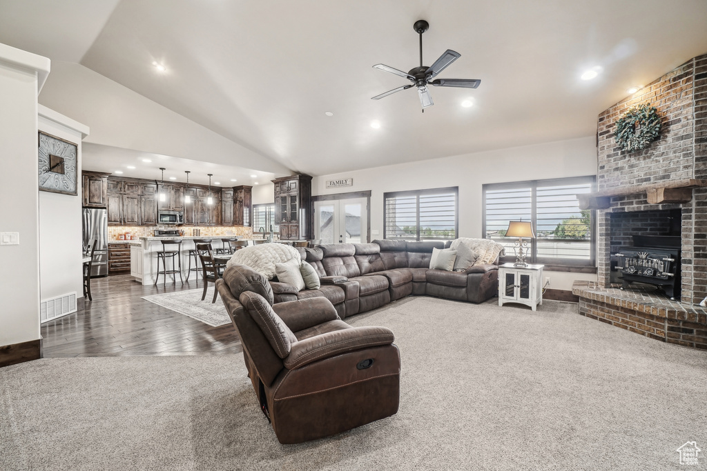 Living room with lofted ceiling, a ceiling fan, dark carpet, recessed lighting, and baseboards