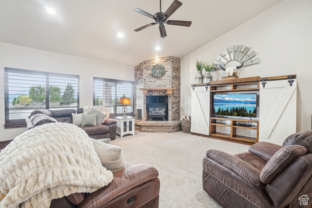 Living room with vaulted ceiling, a fireplace, a ceiling fan, carpet floors, and recessed lighting