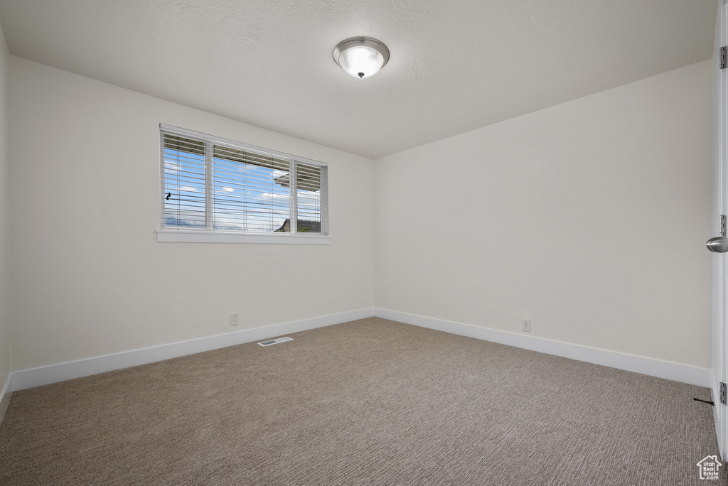 Spare room featuring baseboards and carpet floors