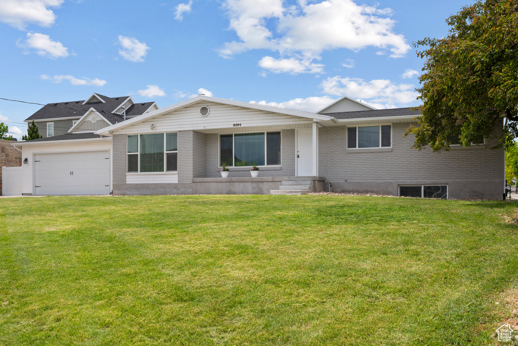 View of front of house with a front lawn and brick siding