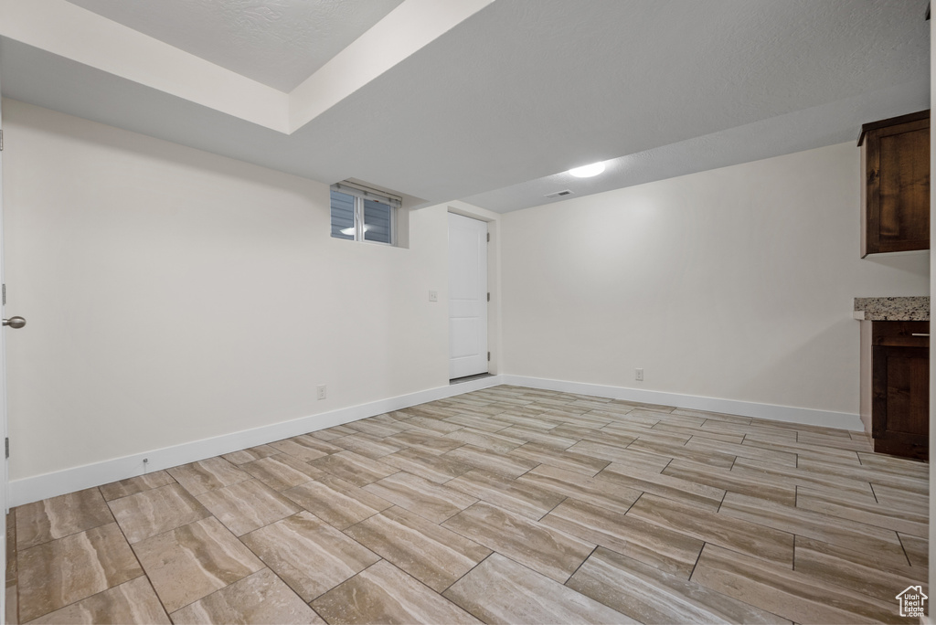 Finished below grade area with baseboards and light wood finished floors