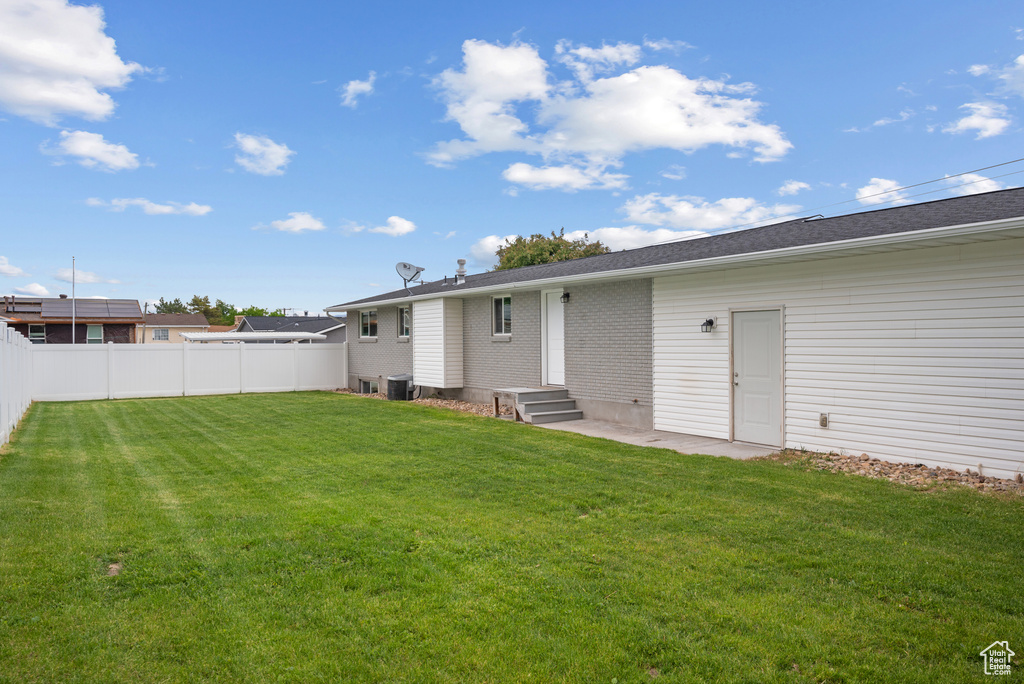 Rear view of property featuring brick siding and central AC unit