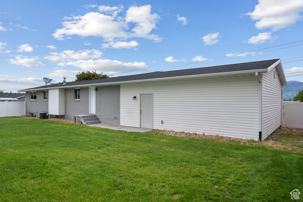 Rear view of house with central air condition unit and brick siding