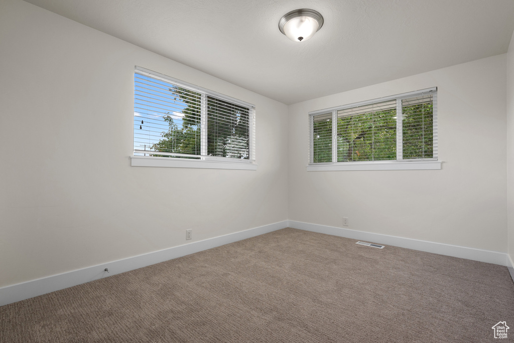 Carpeted spare room with baseboards