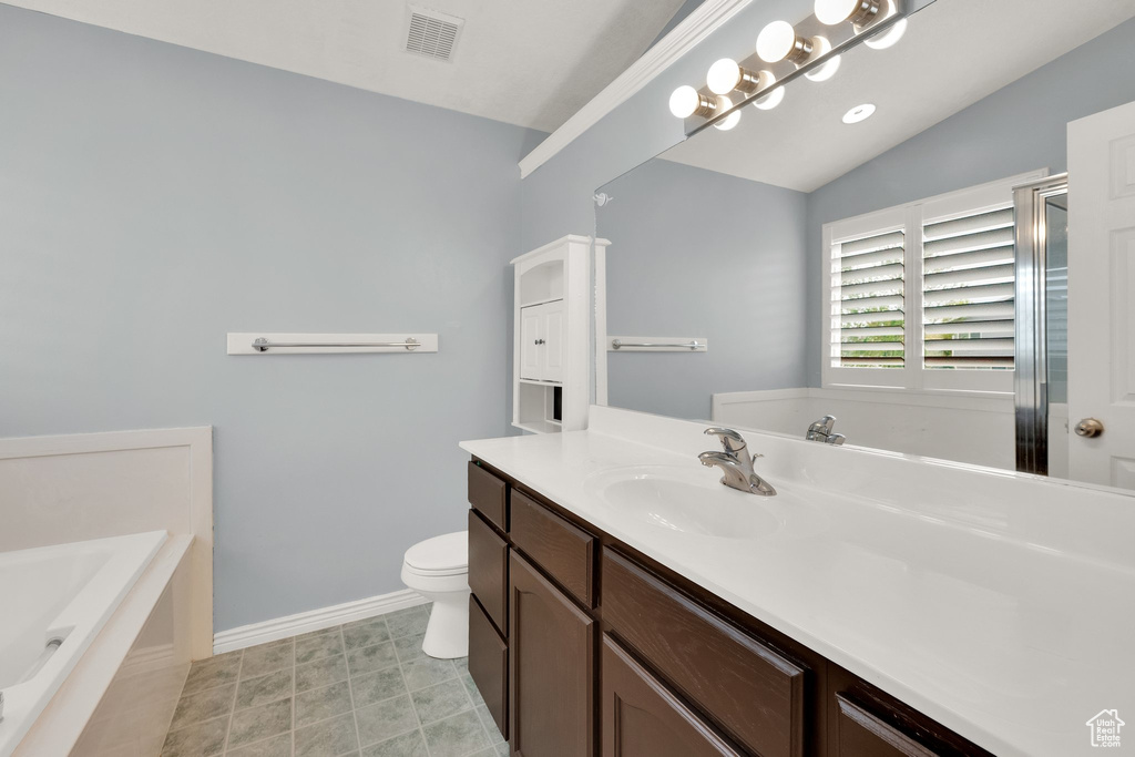 Full bath with lofted ceiling, baseboards, a garden tub, vanity, and toilet