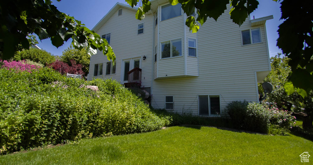 Back of house with a yard
