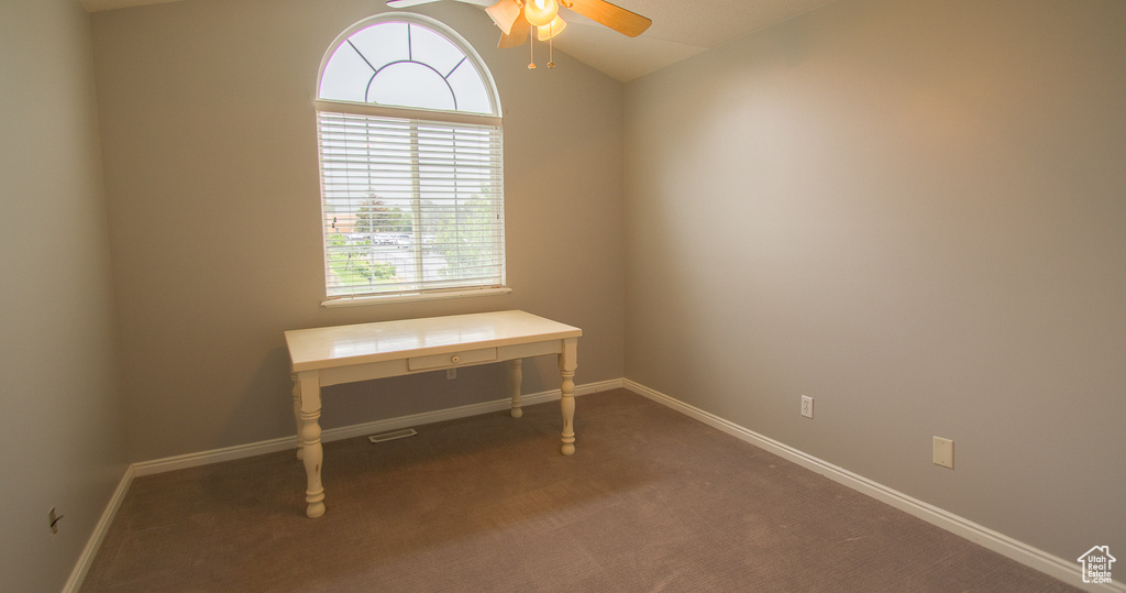 Office space with a ceiling fan, carpet floors, baseboards, and vaulted ceiling