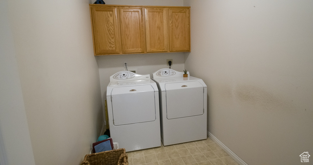 Washroom featuring cabinet space, independent washer and dryer, and baseboards