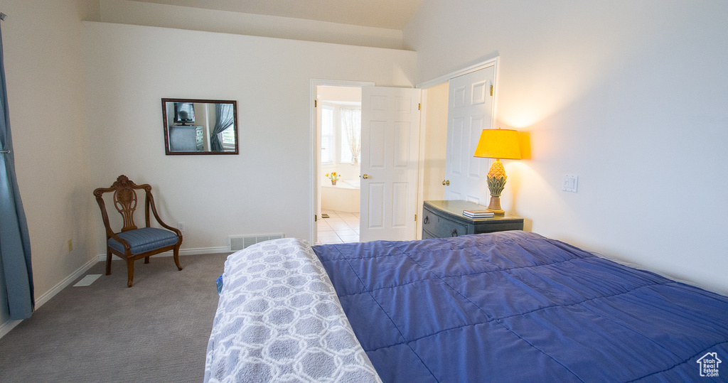 Carpeted bedroom featuring baseboards and ensuite bathroom