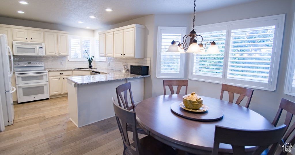 Dining room featuring recessed lighting, light wood-style flooring, and a chandelier