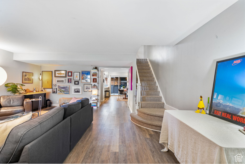 Living room with stairs, wood finished floors, and baseboards