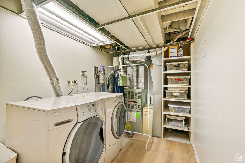 Laundry area featuring independent washer and dryer and light wood-type flooring