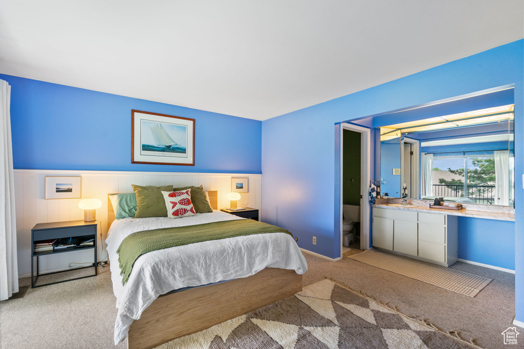 Bedroom featuring light carpet and a wainscoted wall