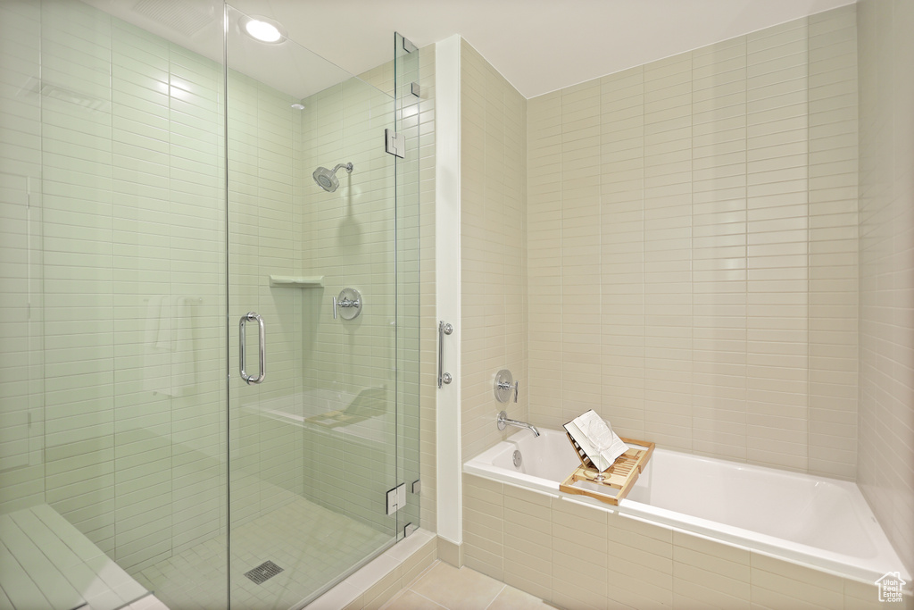 Bathroom featuring tile patterned flooring, a bath, and a stall shower