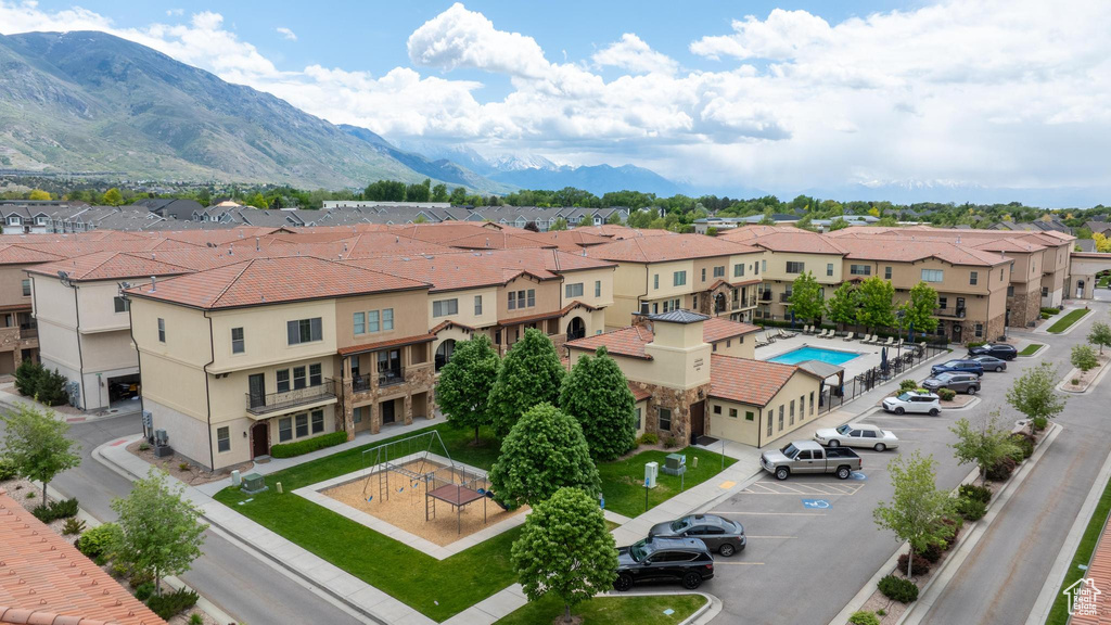 Aerial view of residential area featuring a mountainous background and a pool area