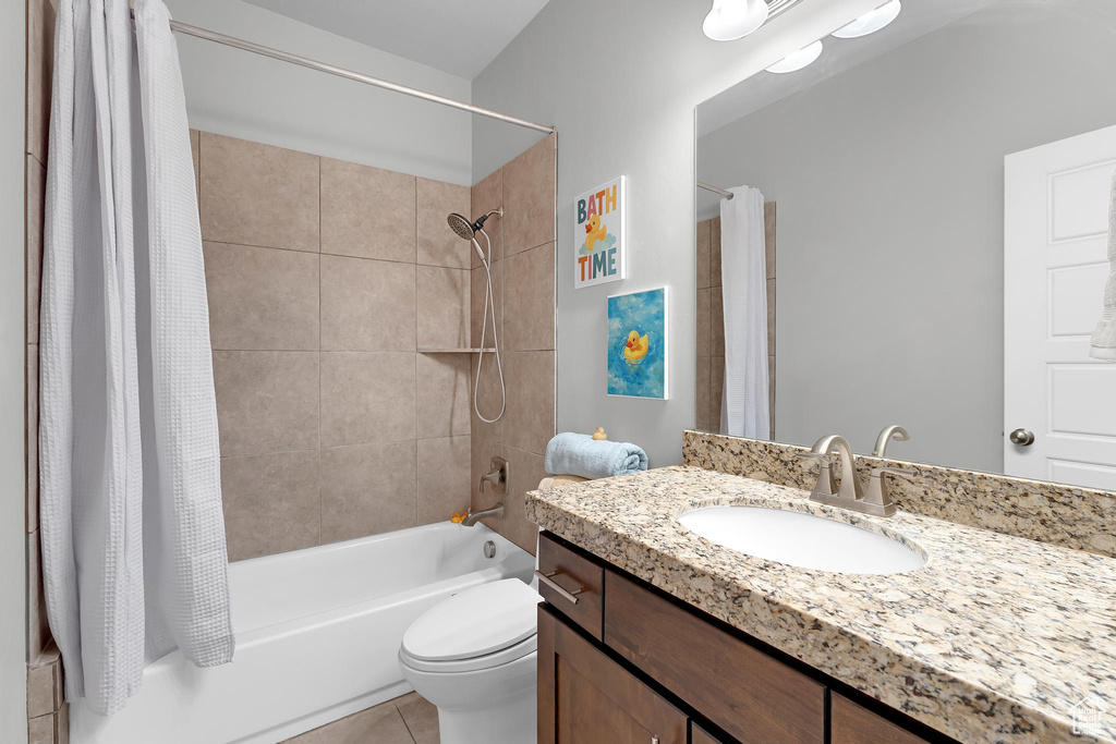 Bathroom with shower / tub combo, tile patterned flooring, toilet, and vanity