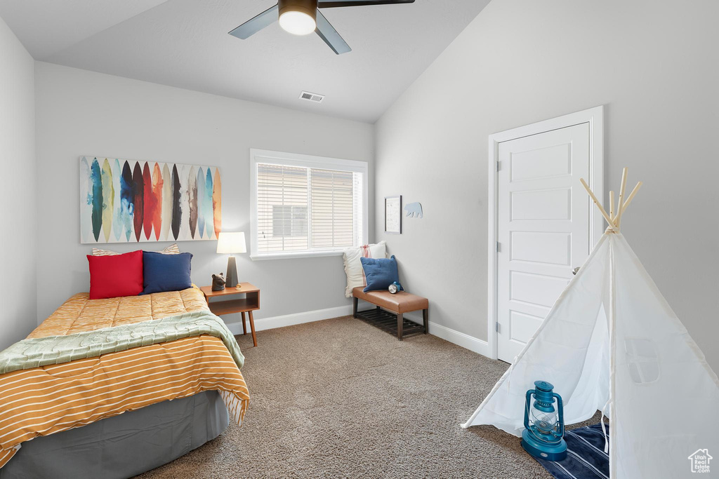 Carpeted bedroom with vaulted ceiling, ceiling fan, and baseboards
