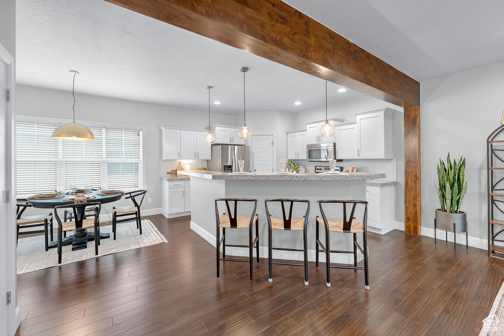 Kitchen with appliances with stainless steel finishes, light countertops, recessed lighting, and white cabinets