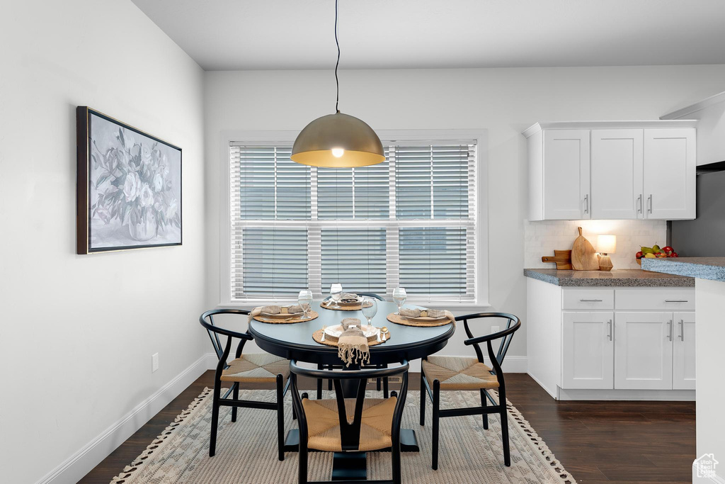 Dining area featuring dark wood finished floors and baseboards