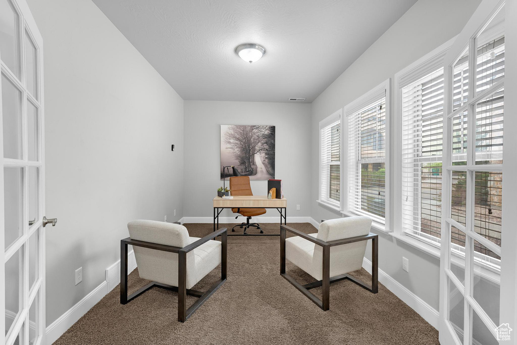 Carpeted office space with baseboards