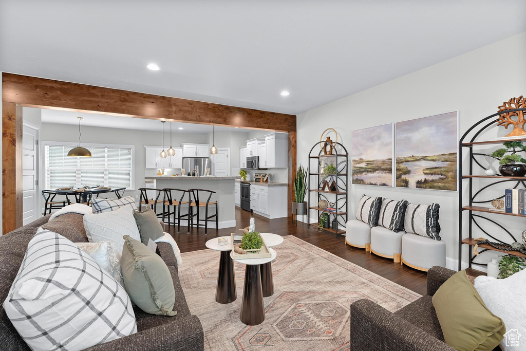 Living area featuring dark wood-type flooring, recessed lighting, and beam ceiling