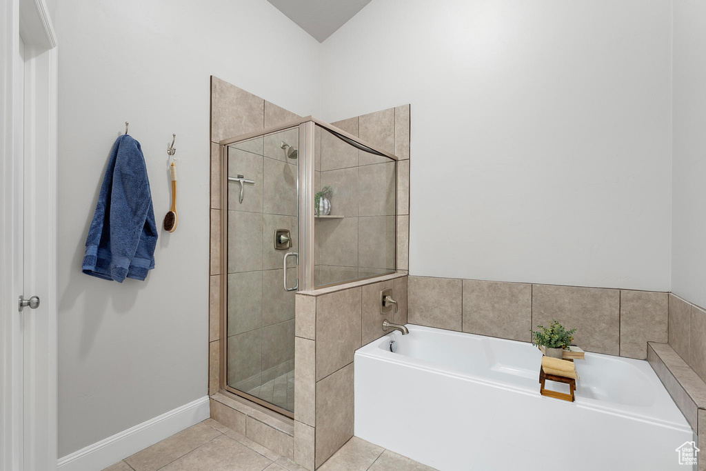 Bathroom with a stall shower, tile patterned flooring, and a bath