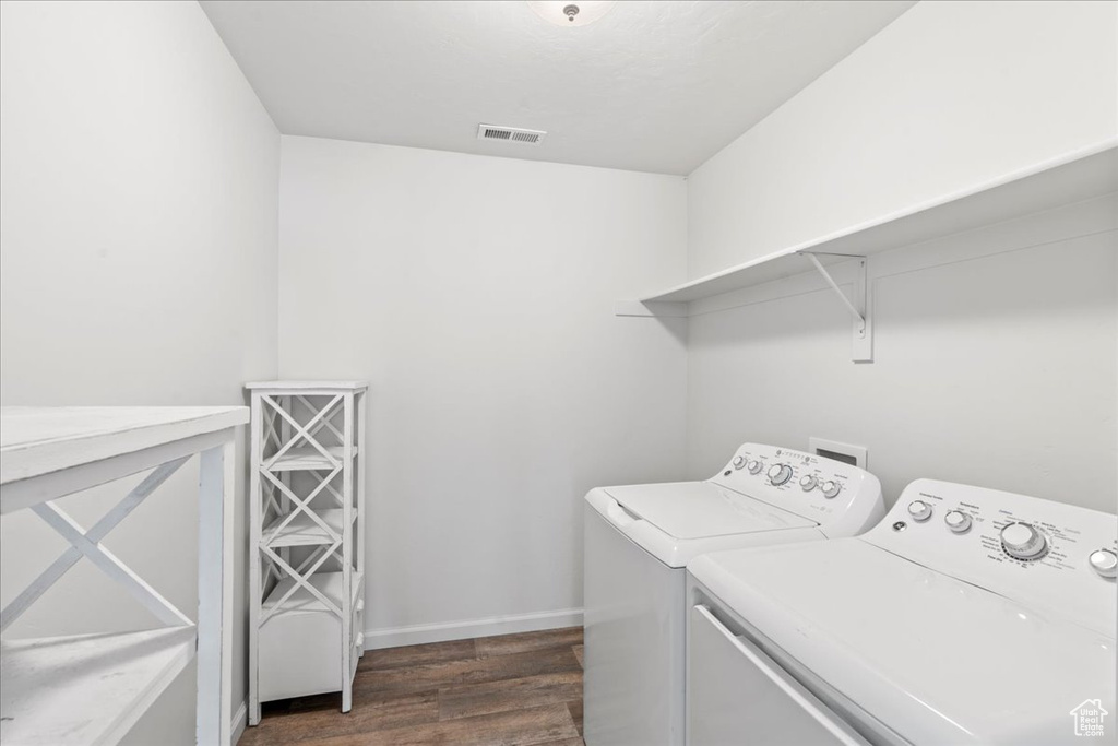 Laundry area with washer and dryer, dark wood-style floors, and baseboards