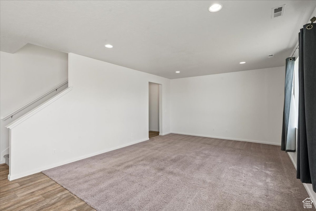 Unfurnished living room with recessed lighting, stairway, and baseboards