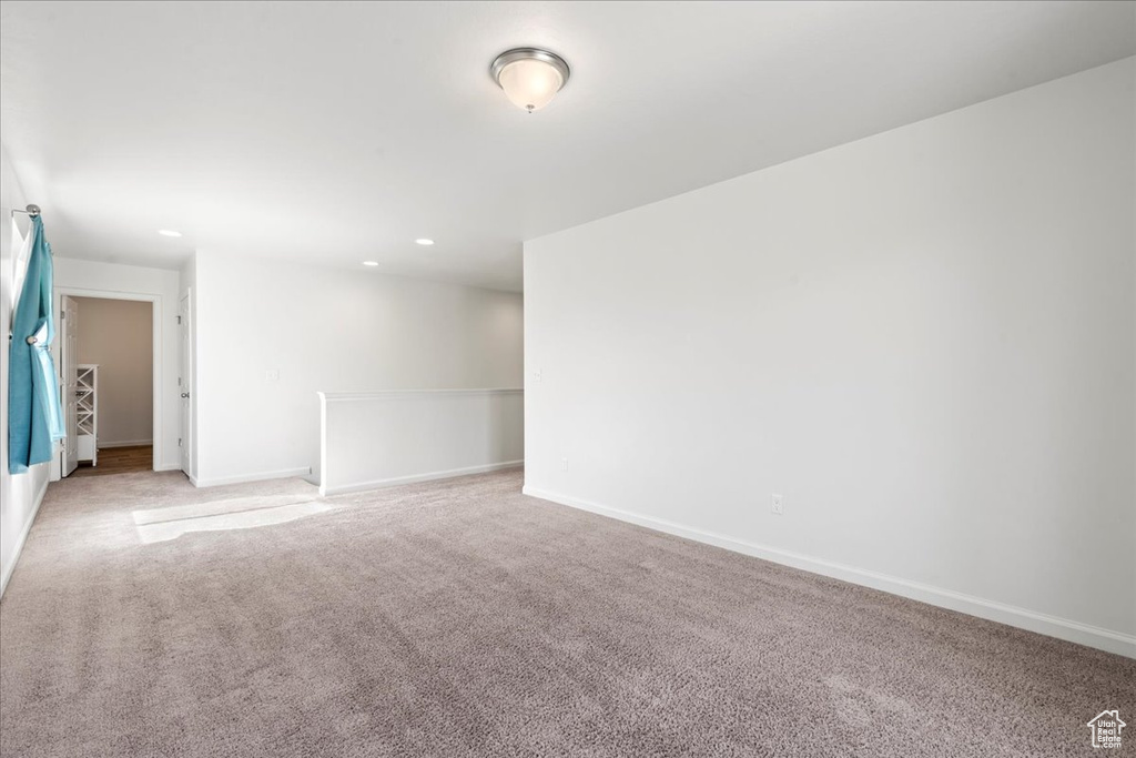 Spare room with light carpet, baseboards, and recessed lighting