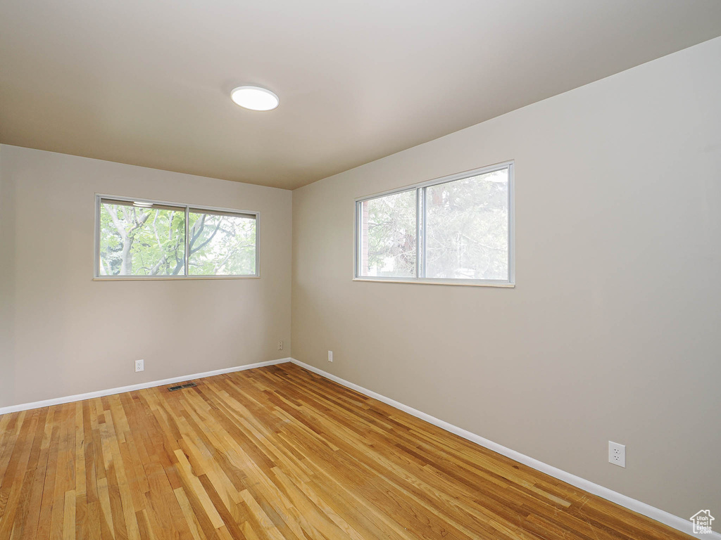 Spare room featuring baseboards and light wood finished floors