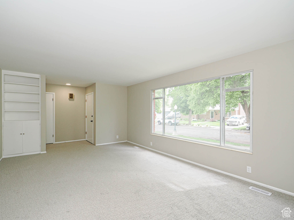 Spare room featuring baseboards and light colored carpet