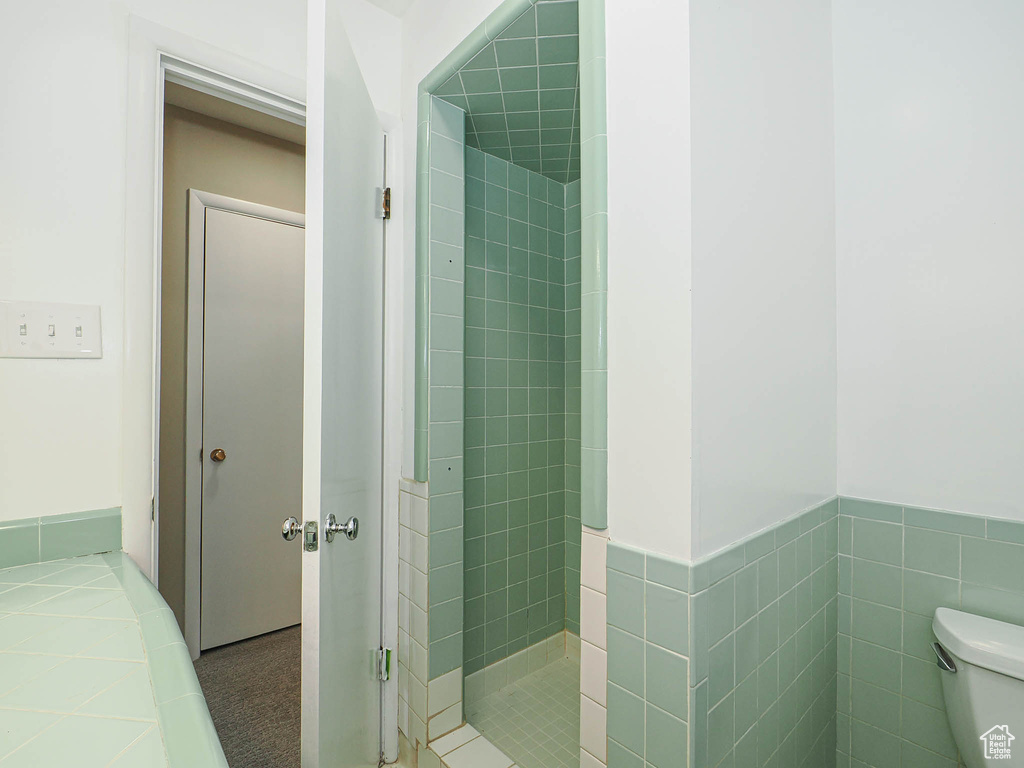 Bathroom with a shower stall, toilet, and tile patterned floors