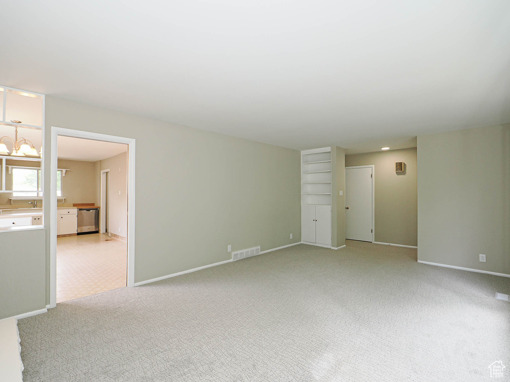 Spare room with baseboards and light colored carpet
