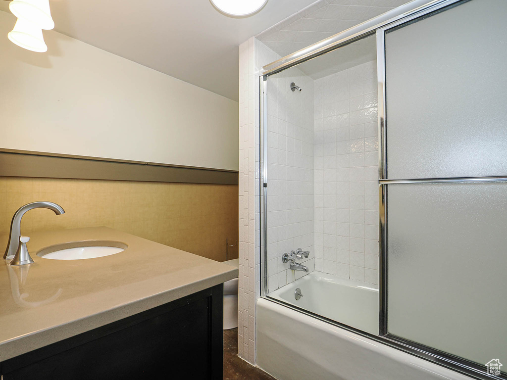 Bathroom with combined bath / shower with glass door and vanity