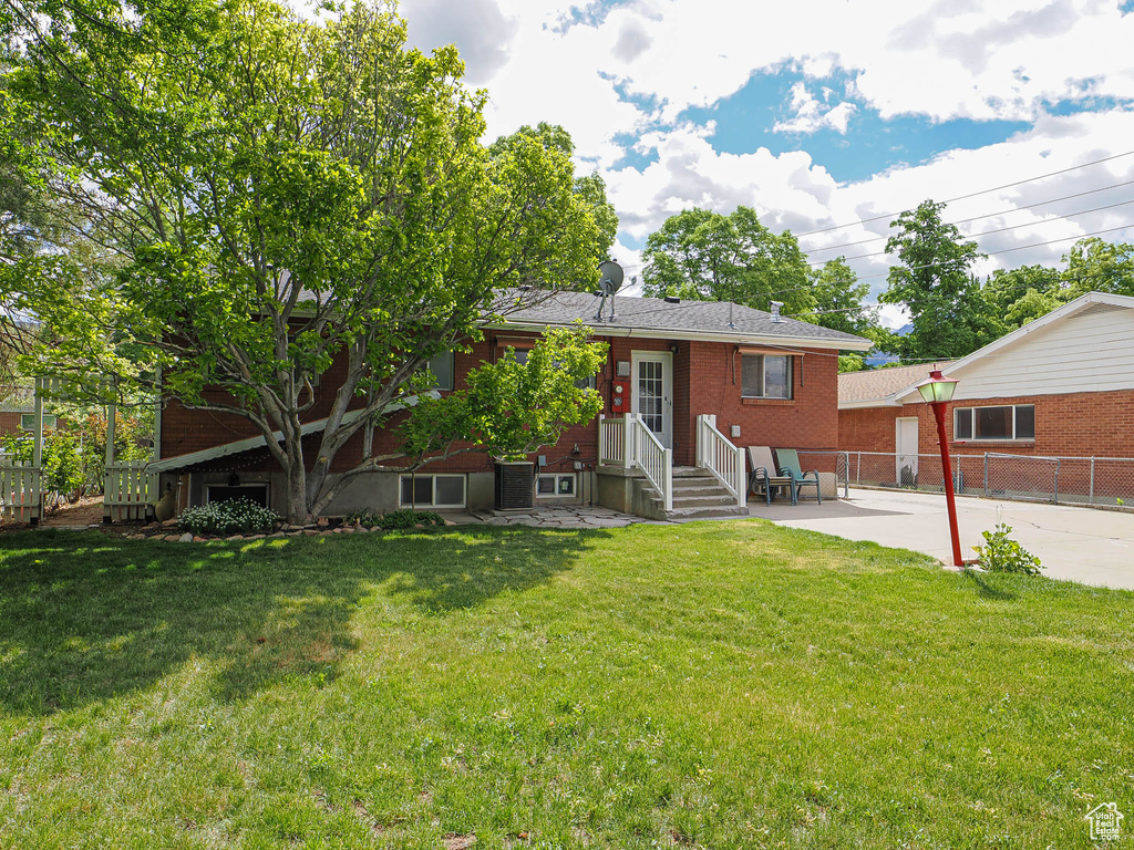 Back of property with entry steps, brick siding, and a patio