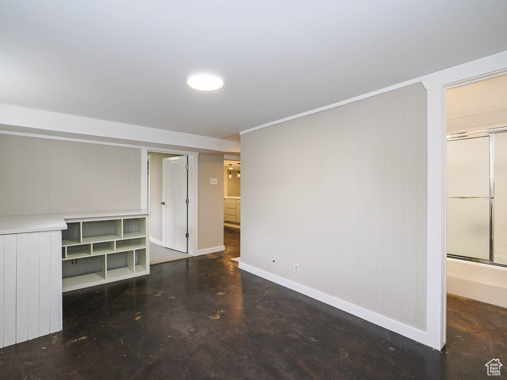 Unfurnished bedroom with baseboards and finished concrete flooring