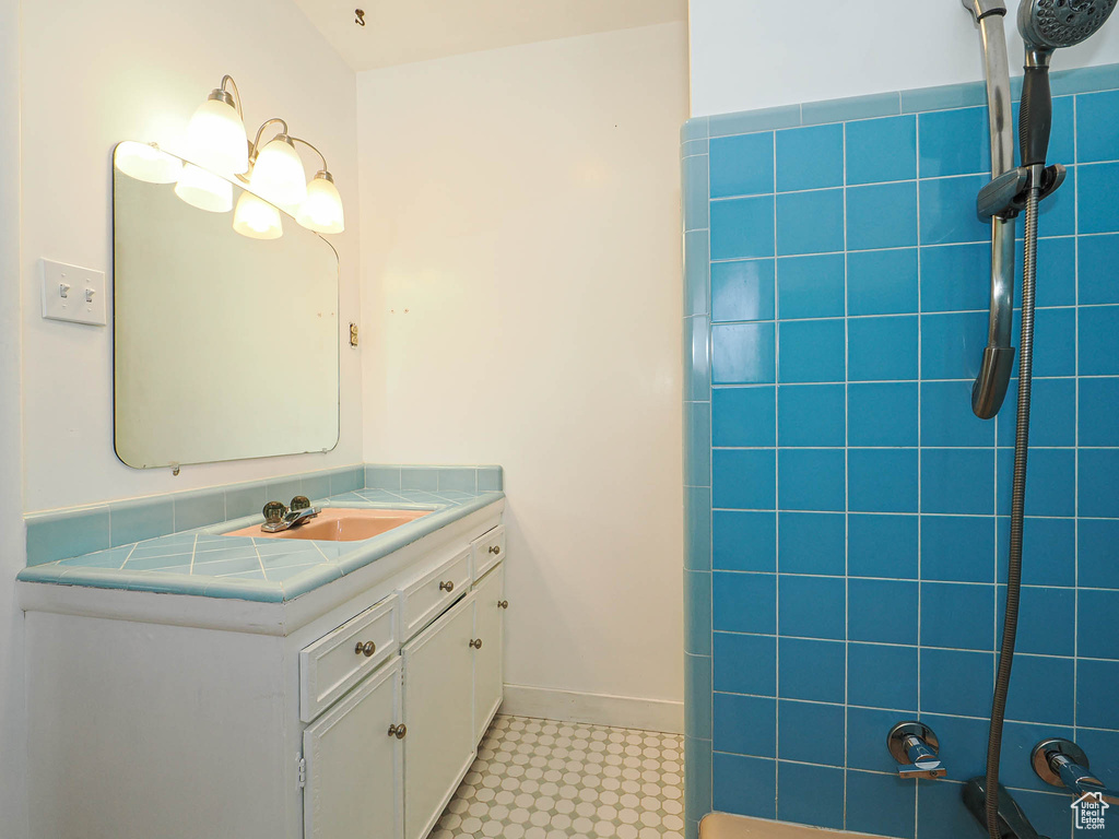 Full bath with tile patterned floors and vanity
