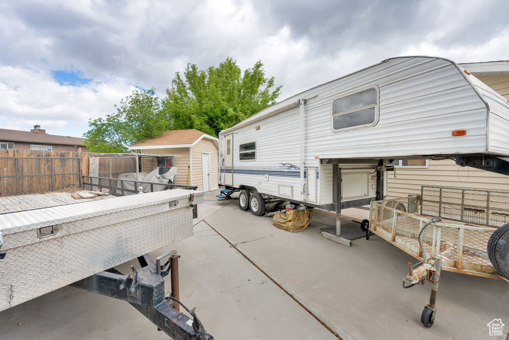 Back of property with a storage shed, a fenced backyard, an outdoor structure, and a patio