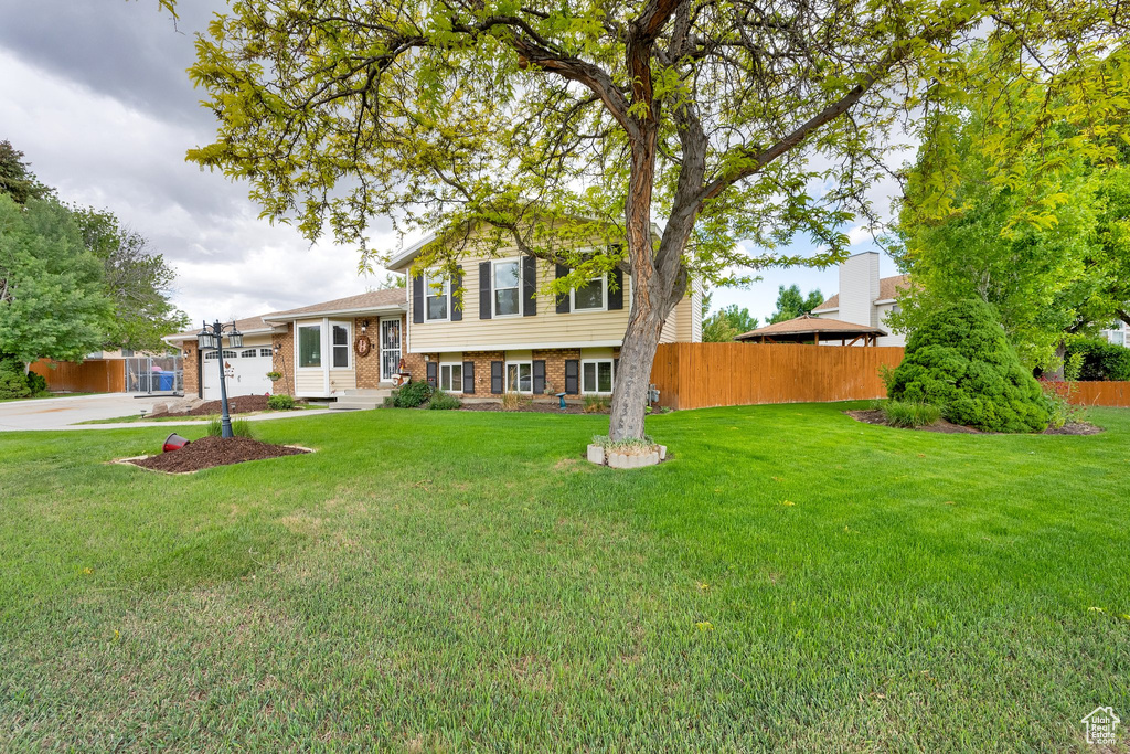 Split level home featuring brick siding, driveway, and a garage