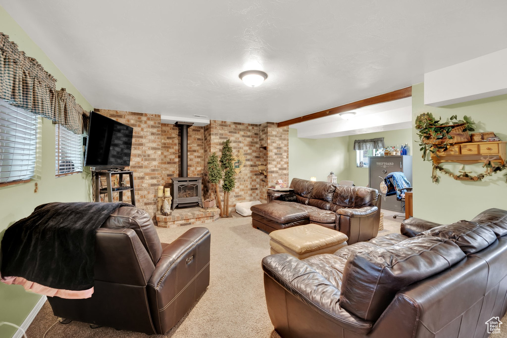 Living room with a wood stove, carpet, and brick wall