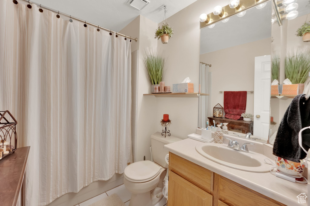 Full bathroom with vanity, toilet, tile patterned flooring, and shower / bathtub combination with curtain