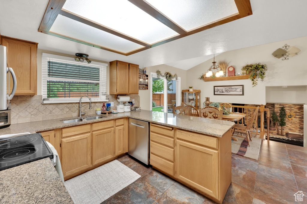 Kitchen featuring a sink, stainless steel dishwasher, a peninsula, and healthy amount of natural light