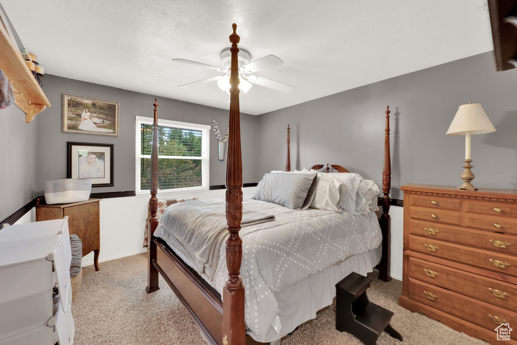 Carpeted bedroom featuring a ceiling fan and baseboards