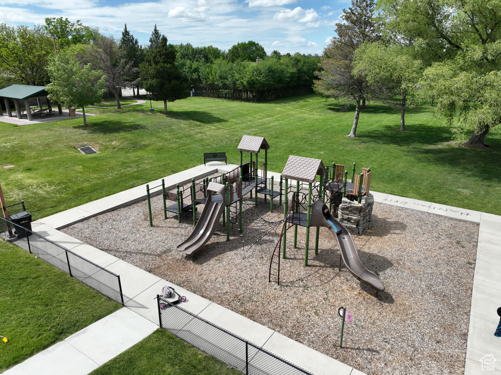 Community playground featuring a lawn, a gazebo, and view of wooded area