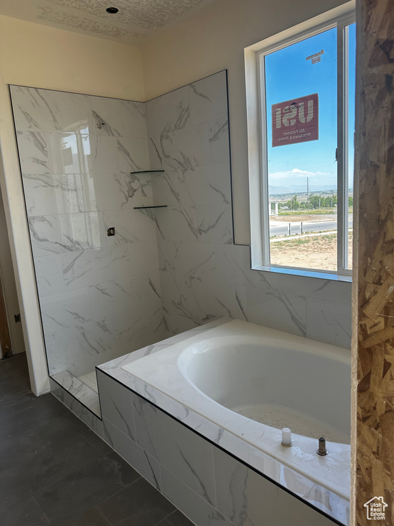 Full bathroom featuring a bath and a marble finish shower