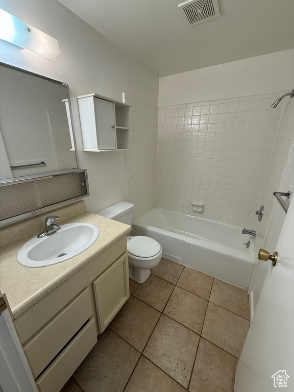Bathroom featuring toilet, tile patterned flooring, vanity, and shower / bath combination