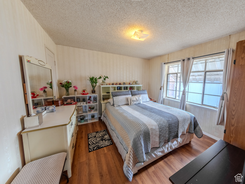 Bedroom featuring a textured ceiling and wood finished floors