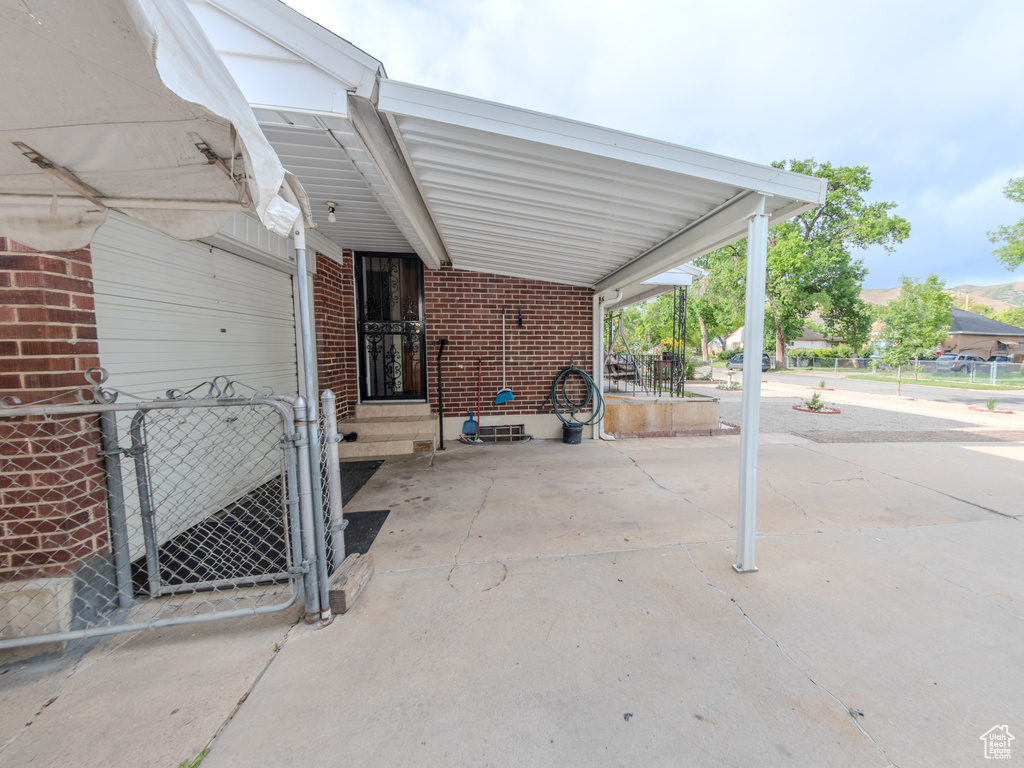 View of patio featuring fence, a carport, and a gate